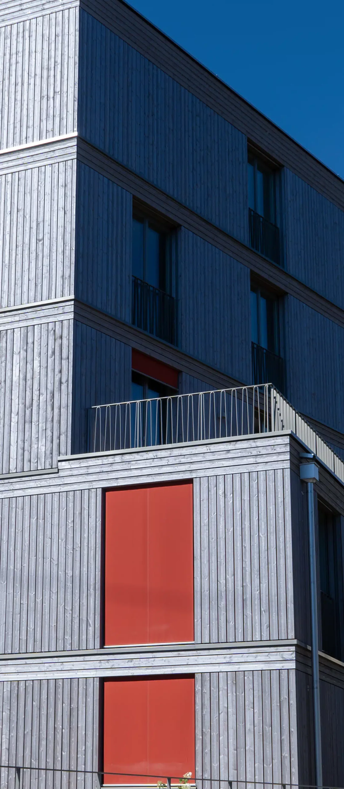 Mehrgeschossiges Wohngebäude mit Holzfassade als Symbol für nachhaltige Projektentwicklung